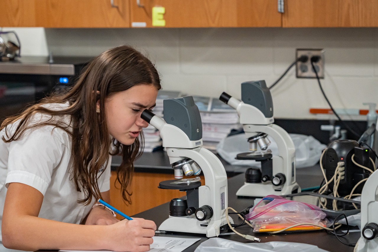 Photo of a girl using a microscope