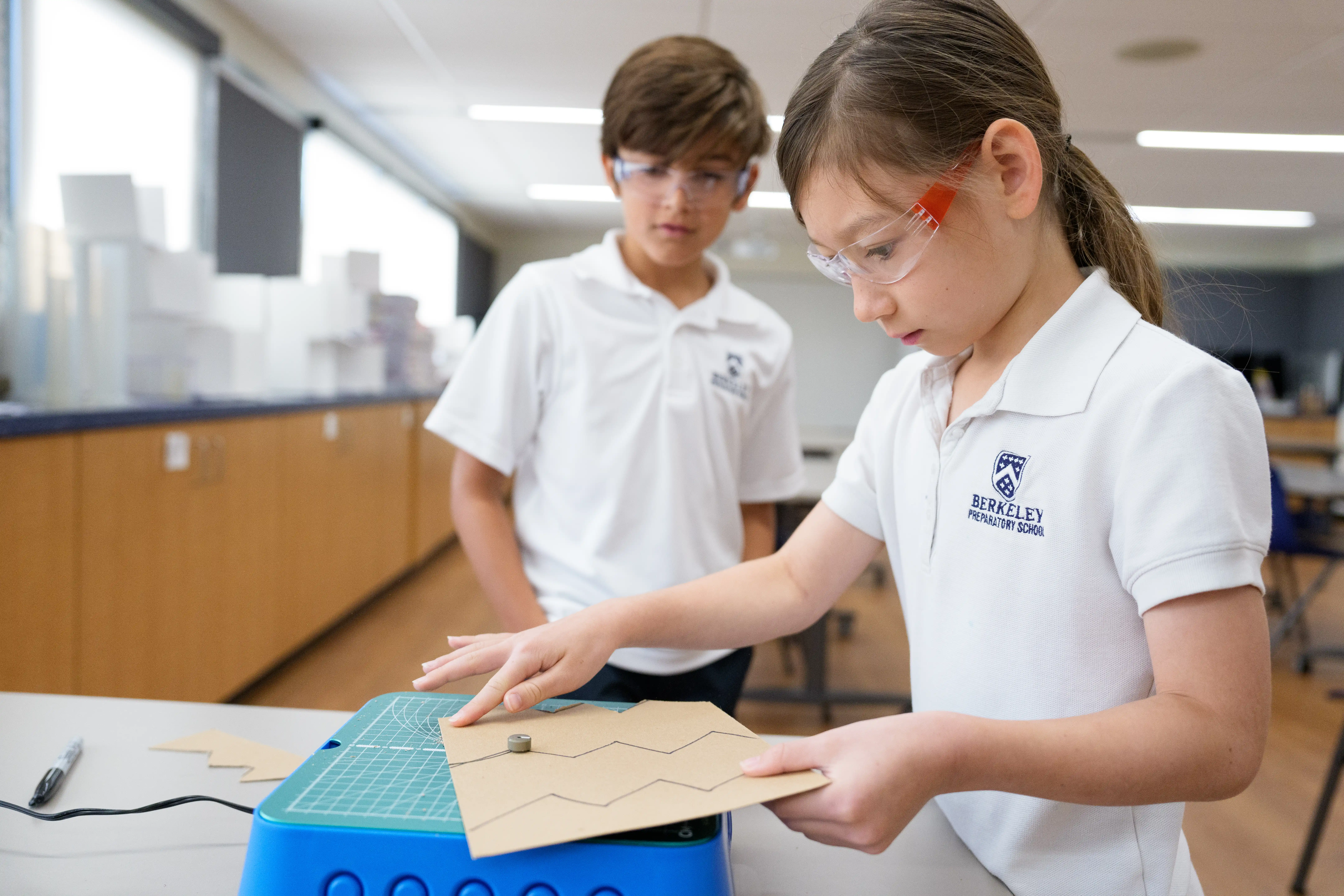 Image of two children using cardboard saws